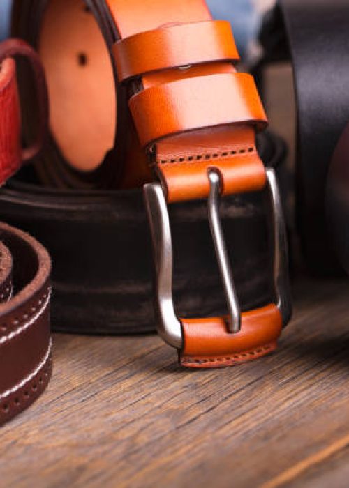 Leather colored belts on a wooden table